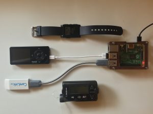 OpenAPS komponentit: Raspberry Pi, Dexcom vastaanotin, CareLink tikku, insuliinipumppu ja Pebble-kello